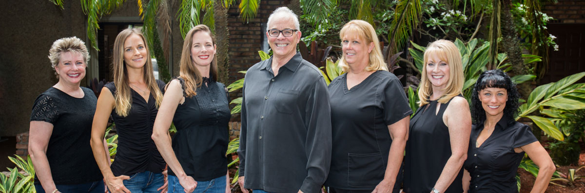 The team at Craig H. Etts, DDS Family and Cosmetic Dentistry smiling with a tropical garden backdrop