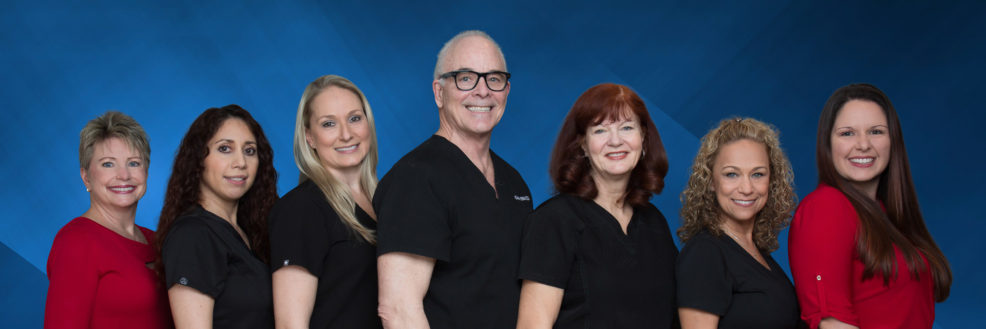 The team at Craig H. Etts, DDS Family and Cosmetic Dentistry smiling with a tropical garden backdrop